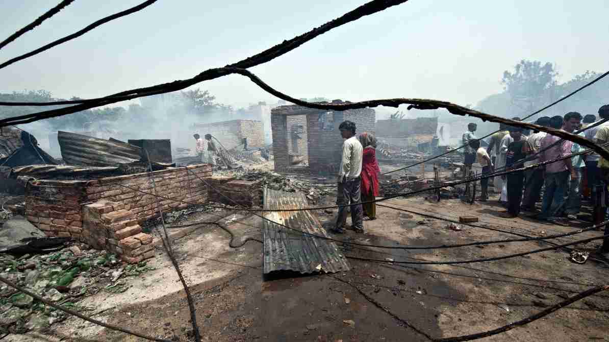 दिल्ली के रोहिणी क्षेत्र में झुग्गियों में लगी आग के बाद का दृश्य, जहां दमकल कर्मी राहत कार्य में जुटे हैं।