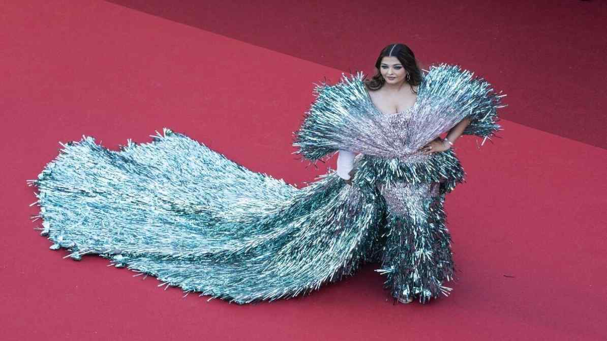 Aishwarya Rai Cannes 2026 के दौरान ब्लू कलर के क्रिस्टल गाउन में रेड कार्पेट पर पोज देती नजर आ रही हैं, साथ में बेटी आराध्या बच्चन भी मौजूद हैं।